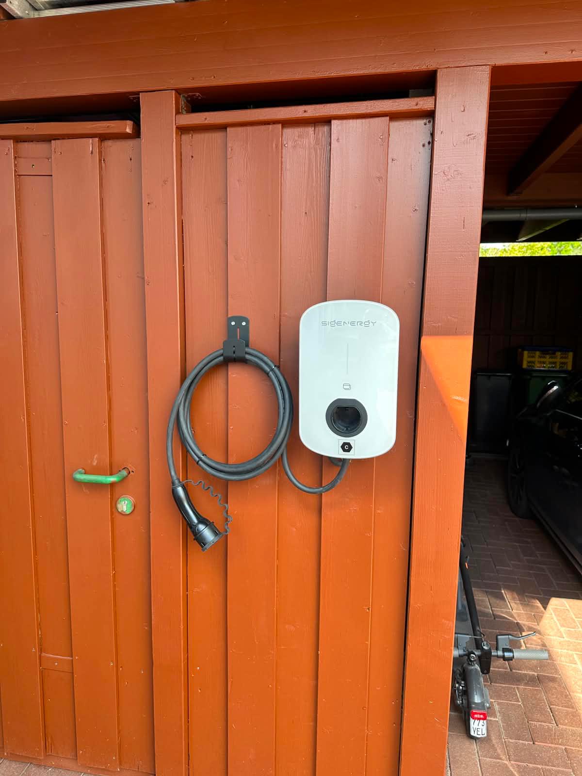 Sigenergy Wallbox an Holzwand mit Ladekabel